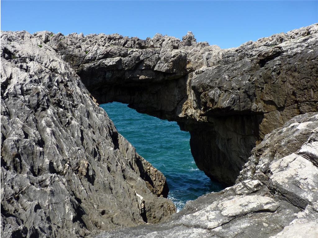 Arco denominado Salto o Puente del Caballo, desde donde se extiende la grieta que comunica la playa de Cobijero con el acantilado