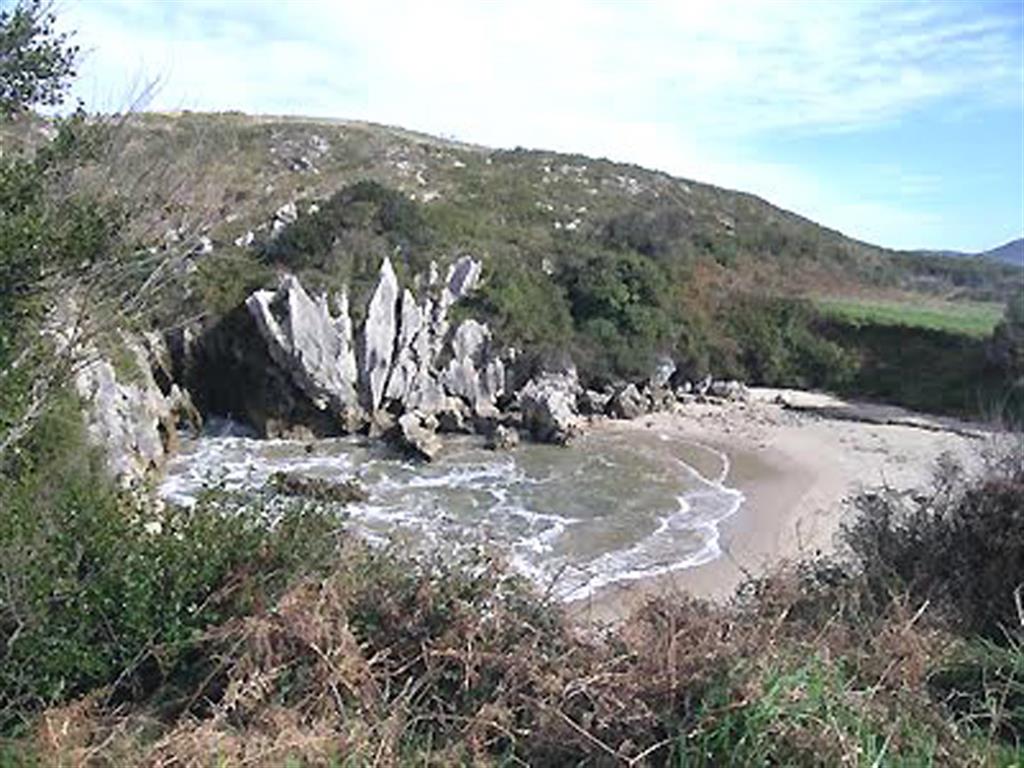 La playa vista desde el lado occidental con la marea en posición media; al fondo, se observan los pináculos kársticos.