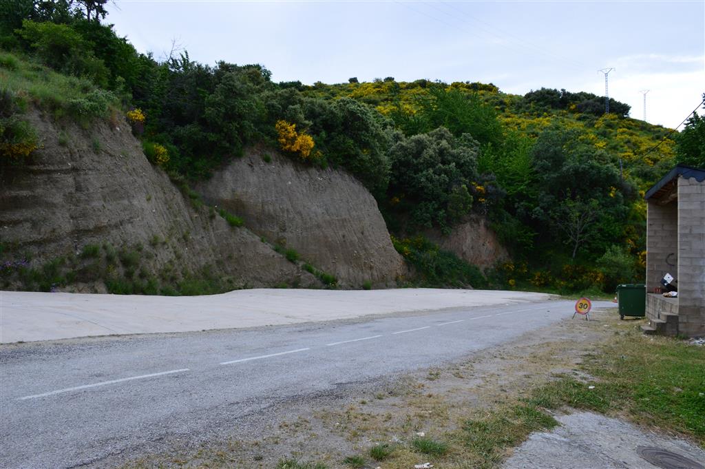 Vista general del depósito de grèzes litées de Saceda. Se trata de un talud de la carretera frente a la parada de autobuses, que presenta un mal estado de conservación.