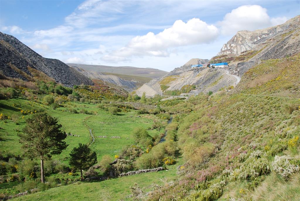 Vista general del valle de La Baña y escombreras mineras que flanquean el valle y que llegan hasta el mismo borde del Monumento Natural.