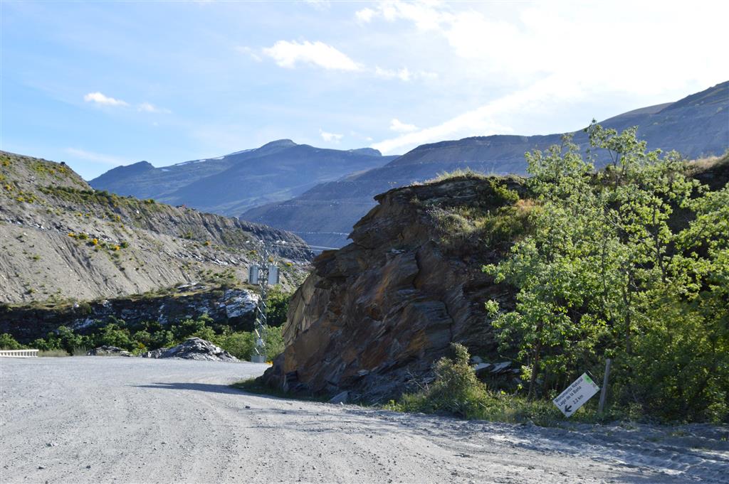 Acceso al Lago de la Baña, por una pista minera, y letrero indicativo del acceso al Monumento Natural (en la parte inferior derecha).