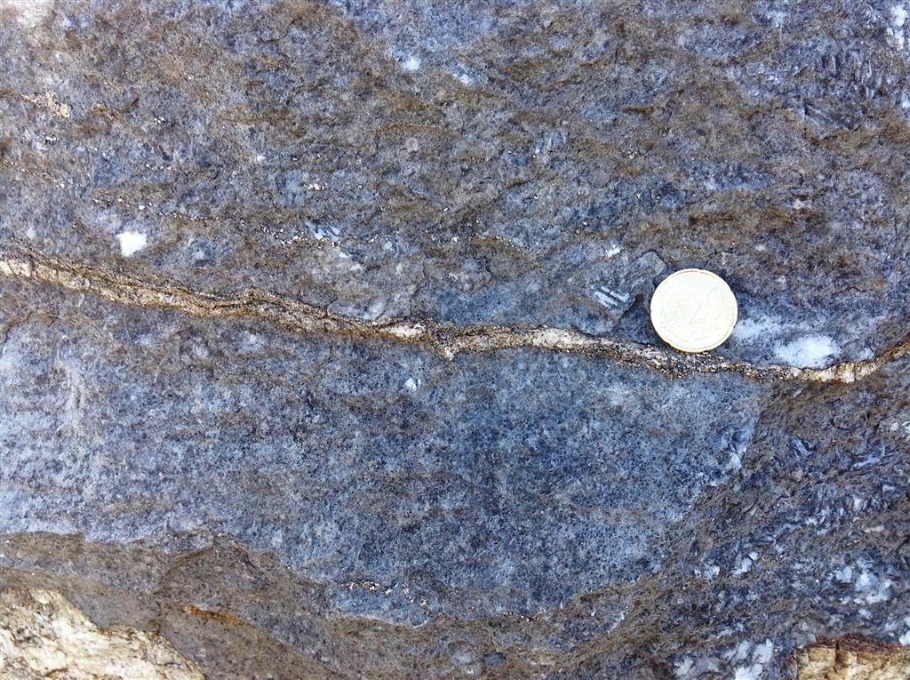 Nivel milimétrico de roca silicatada en mármol recristalizado. La roca silicatada podría corresponder a un antiguo nivel volcánico depositado coetáneamente con la caliza precursora del mármol.