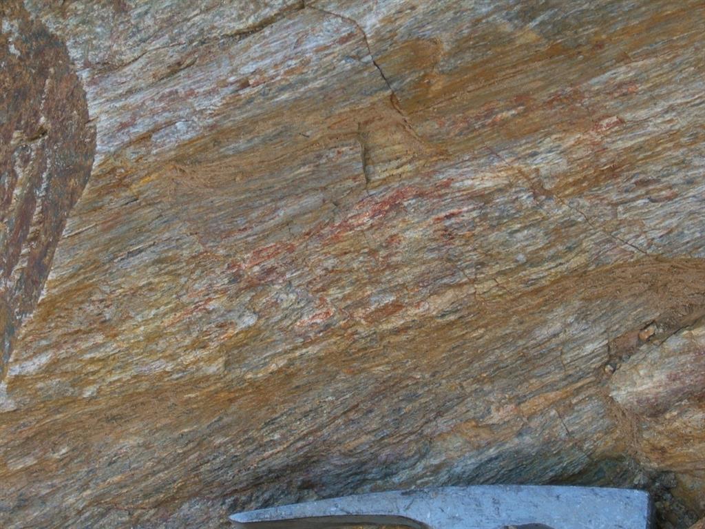 Foliación milonítica sobre granitoides, de la Banda de Cizalla de Toledo. Hoja 625 (Lagartera). Trinchera de la CM-4100 (UTM-ETRS89, entre X: 312.992; Y: 4.420.649 y X: 313.045; Y: 4.420.743). S a la izquierda.