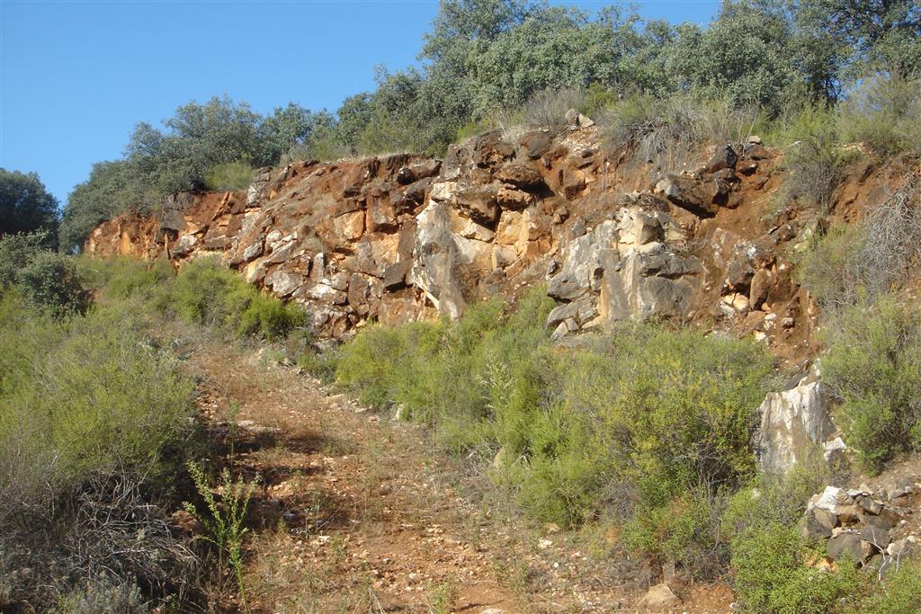 Talud de una antigua explotación donde se pueden observar los gruesos paquetes de carbonatos que forman los marmoles dolomíticos explotados.