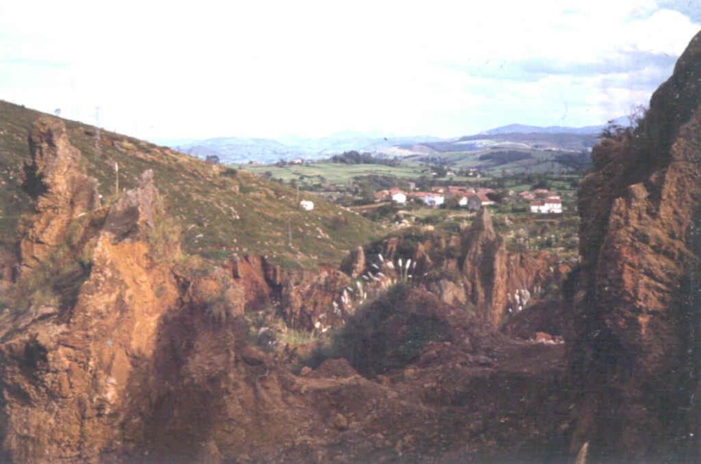 Explotación de Óxidos de Fe en las arcillas de descalcificación. Al fondo, el pueblo de Cabárceno.