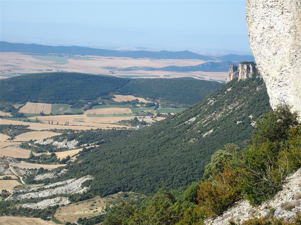 Perfil compuesto de las laderas, con un cantil vertical y un talud tendido cubierto por derrubios de ladera y bloques.