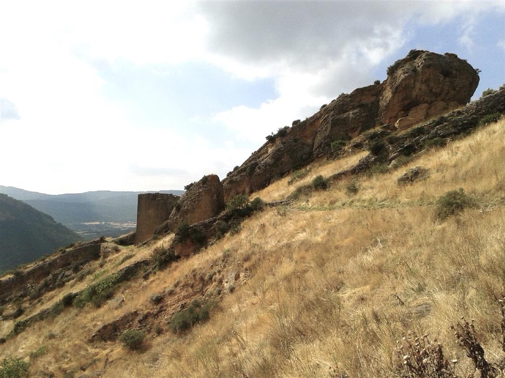 Barra de conglomerado sobre nivel infrayacente de areniscas. Su notable resistencia a la erosión genera un importante resalte en lo alto de la sierra. Muestra un buzamiento suave a moderado hacia el sur.