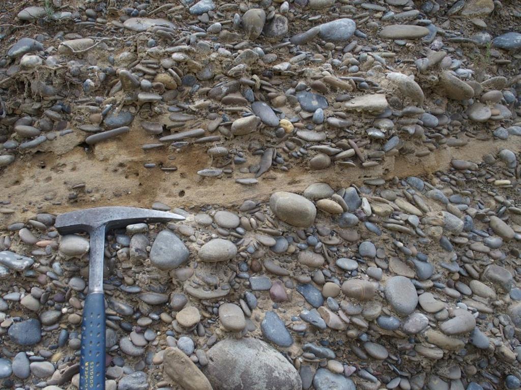 Detalle de los cantos redondeados de caliza y arenisca en fábrica granosostenida de la unidad pleistocena.