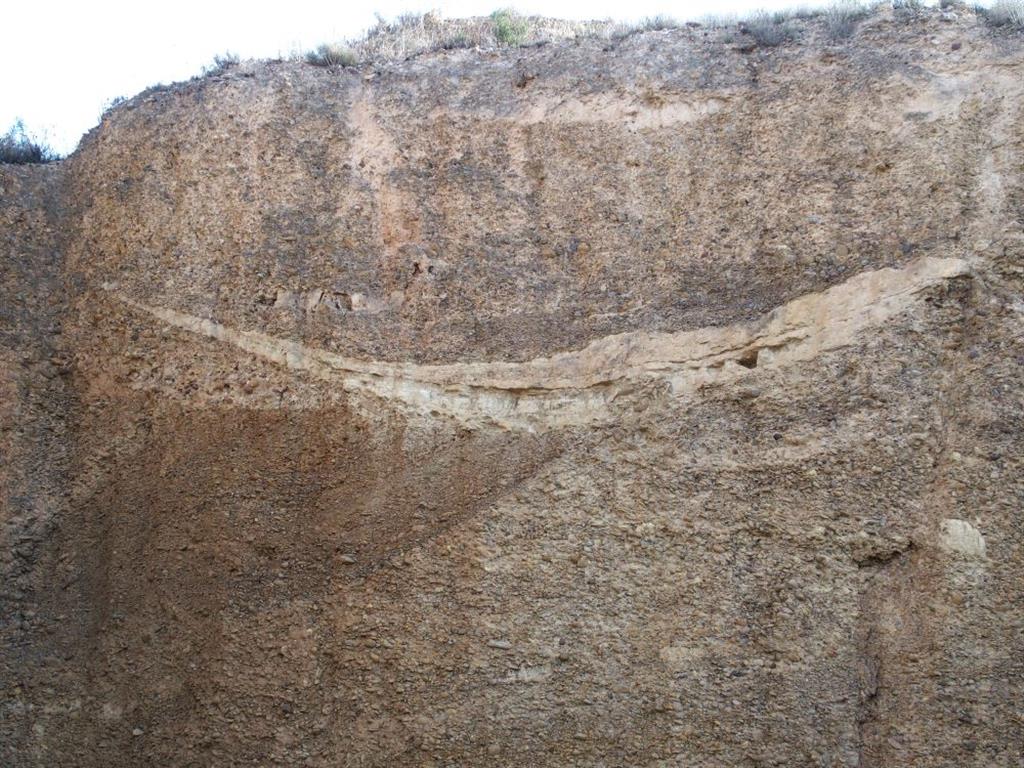 Nivel granular de terraza fluvial alta del Ebro. Se observa un paleocanal con relleno arenoso y morfología cóncava erosiva.