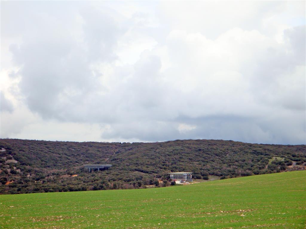 Panorámica desde la pista de acceso al yacimiento desde Ibeas de Juarros. Se observa la instalación para la recepción de visitantes a la derecha y los andamios para acceder a Gran Dolina.