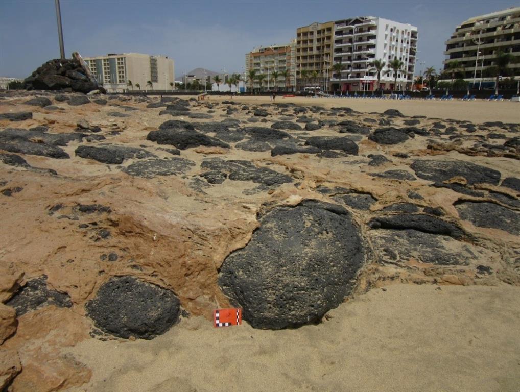 Vista de detalle de la playa de arenas fosilizada sobre bolos basálticos procedentes de la erosión de las lavas