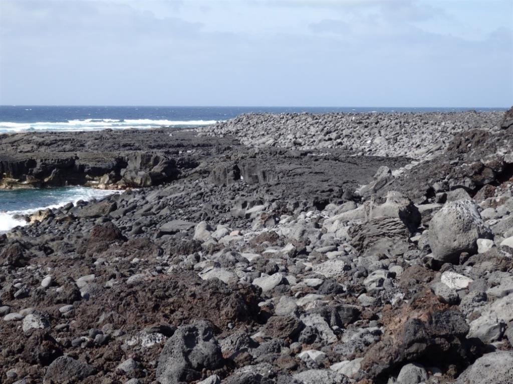 Vista general de la barra supramareal de cantos de la playa del Cochino sobre la plataforma erosiva desarrollada en las lavas de Timanfaya