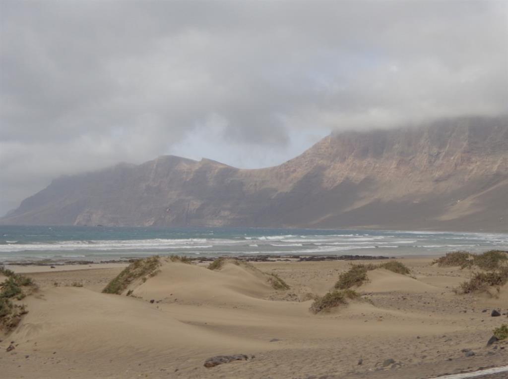 En primer plano las arenas eólicas en el borde norte del Jable, en Caleta de Famara. Desde este punto avanzan hacia el sur de la isla