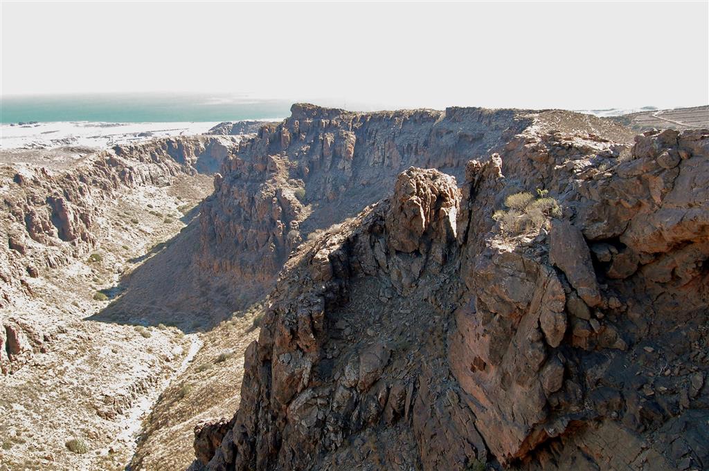 Vista del barranco Hondo hacia aguas abajo en el tramo bajo, donde el cauce reduce su encajamiento (<200m) en las coladas fonolíticas de los Llanos de Amurga y empieza a ensanchar la sección del cañón (>200m).