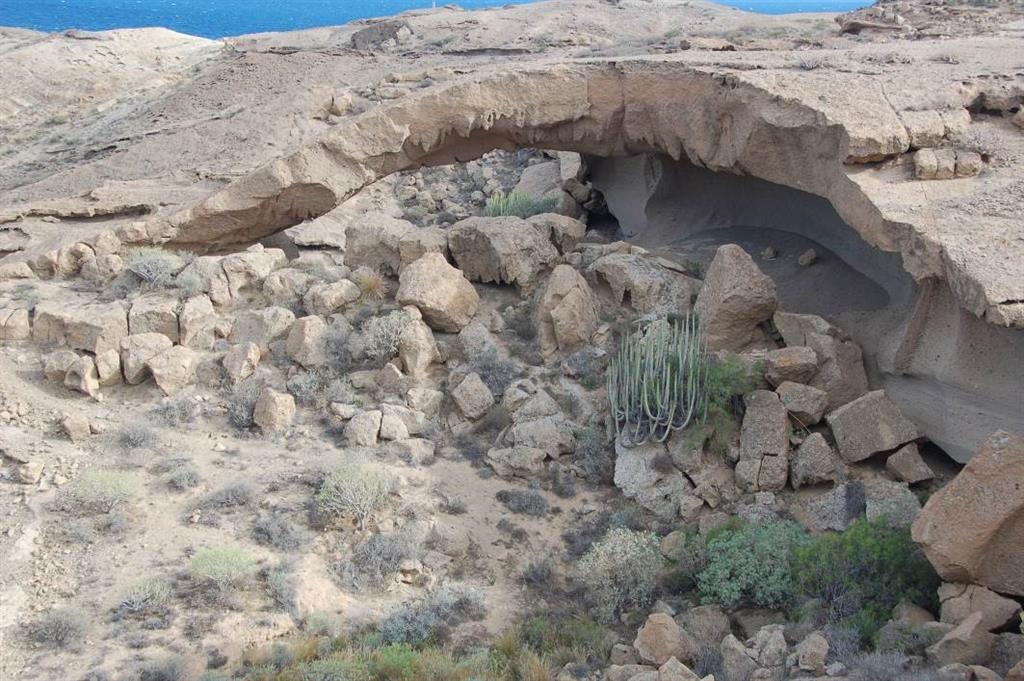 Arco de tosca de Tajao visto desde el norte. En primer término, una de las dos canteras de toba excavadas en una de las ignimbritas del Miembro El Porís cuya actividad originó el espolón de toba en el que se desarrolló el arco.