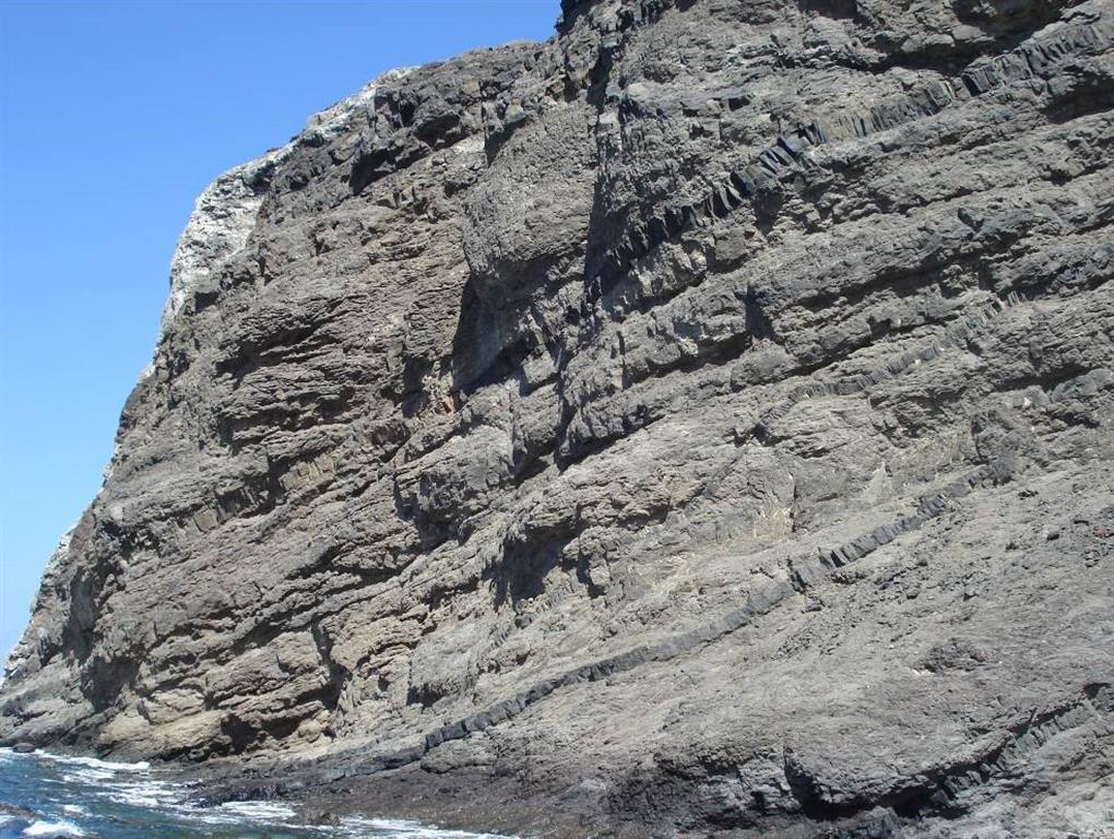Vista general de la secuencia de lavas del Edificio Antiguo Inferior cortada por varios diques inclinadas en el puerto de Alojera