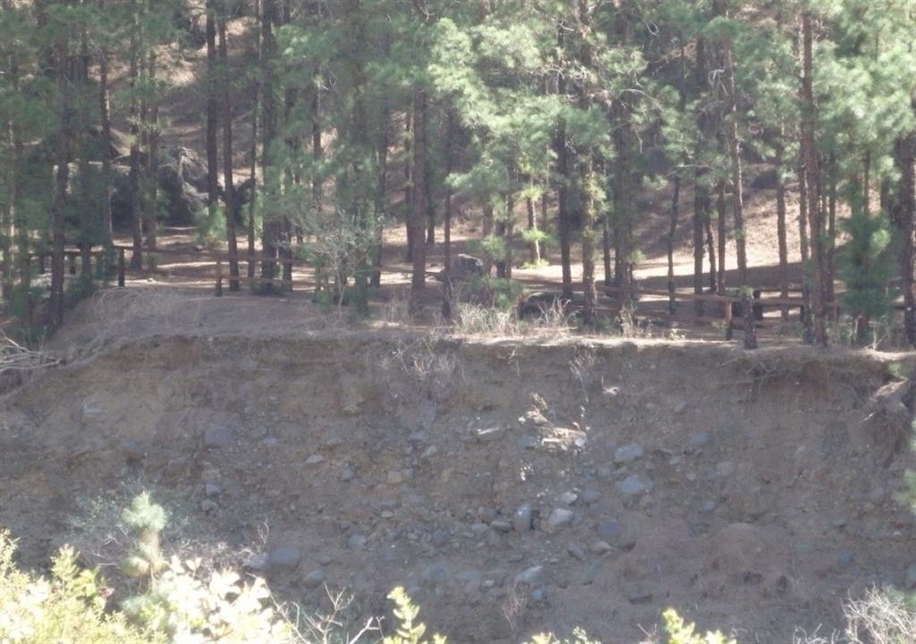 En primer plano los depósitos torrenciales actuales de bloques y cantos de la Playa de Taburiente en la zona de acampada del Parque Nacional. En ambos márgenes se disponen las terrazas del Holoceno superior. Al fondo la pared de la Caldera, en segundo plano el Roque Salvaje. Año 2020