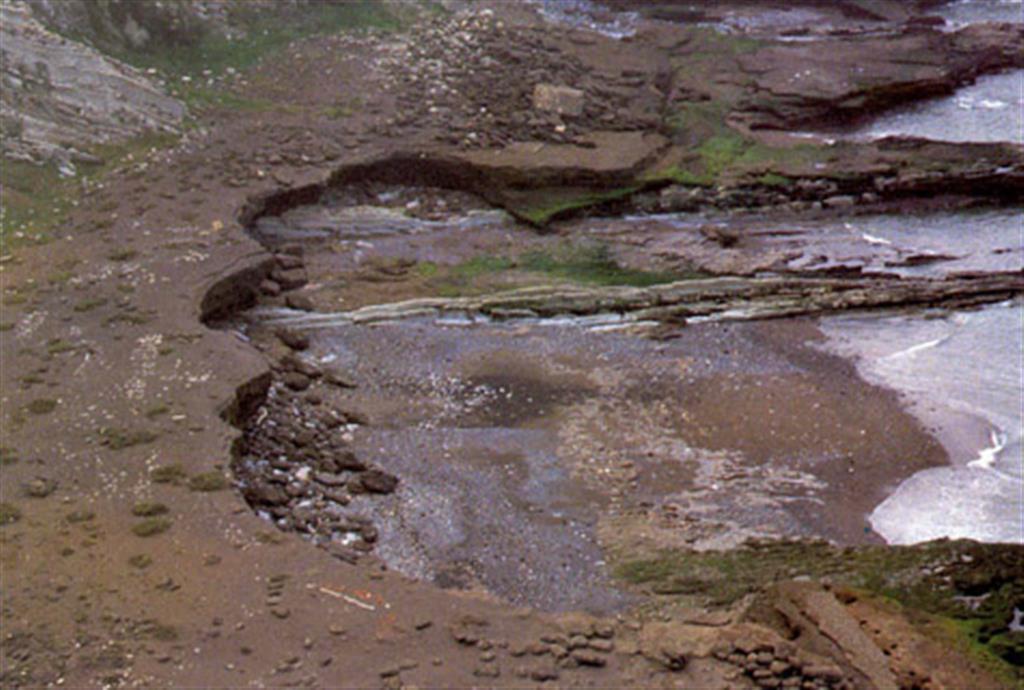 Playa cementada de Tunelboca, al pie de Punta Galea. El oleaje ha erosionado el frente de las arenas cementadas, tallando un microacantilado en el que puede observarse la estructura interna de la playa. (Foto: Diputación Foral de Vizcaya - LURGINTZA)