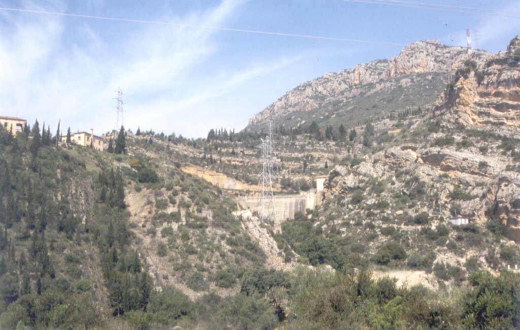 Fotografía del área de la presa de Santa Ana, donde se observan conglomerados (centro) discordantes sobre capas verticales de la escama de Monderas, pero cabalgados por el N. por la escama de Yedra.