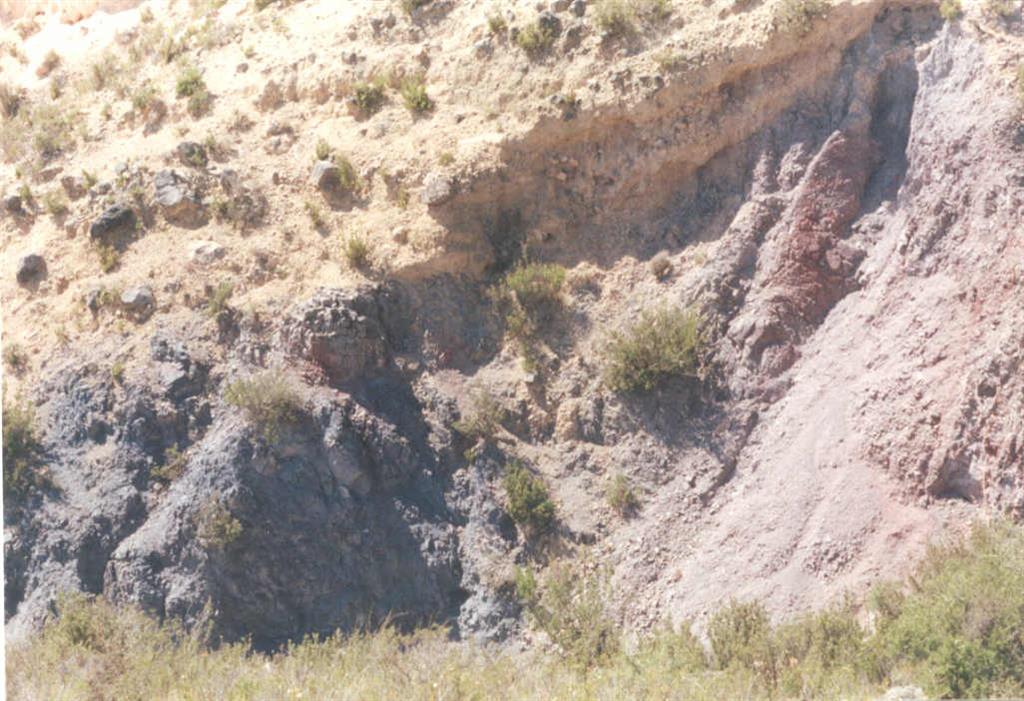 En el mismo lugar, chimenea de salida de basaltos espilitizados. La roca de caja corresponde a las facies Keuper, y el contacto se encuentra rubefactado.