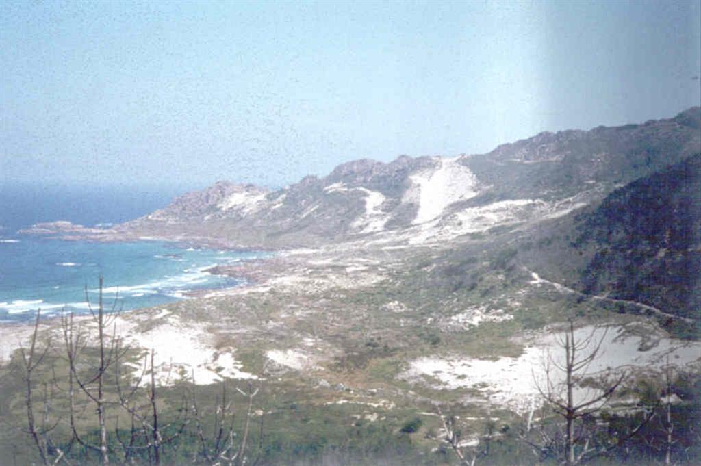 Panorámica de la playa do Trece, obsérvese como las arenas "trepan" materialmente sobre los relieves graníticos.