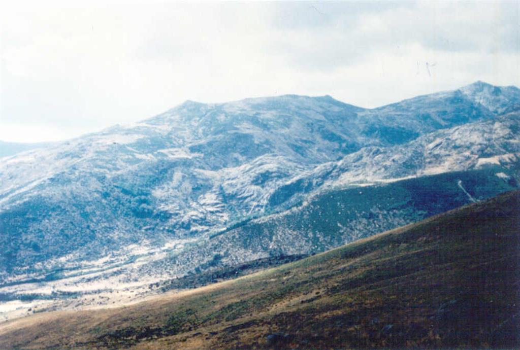 Paisaje del entorno de la Laguna del Duque (fondo a la derecha) con sendas morrenas laterales, circo glaciar en el centro, y modelado glaciar con formas aborregadas en granito.