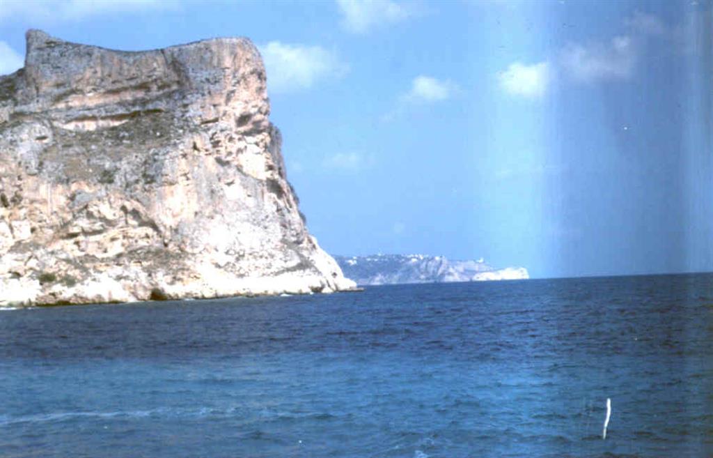 En primer plano Morro Castell y costa acantilada. Al fondo Isla del Descubridor y Cabo de la Nao.