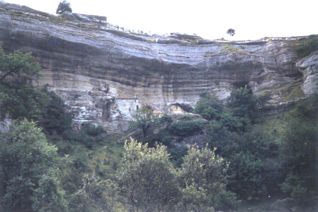 Panorámica del circo de calizas del Cenomaniense con las cuevas de San Bernabé. Ermita del mismo nombre en una de las bocas del karst.