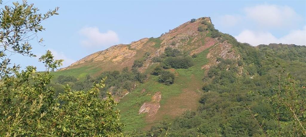 Silueta del monte Mendaur desde la vertiente sur. Se observa cómo su pendiente moderada está asociada al buzamiento de las capas de areniscas y conglomerados triásicos.