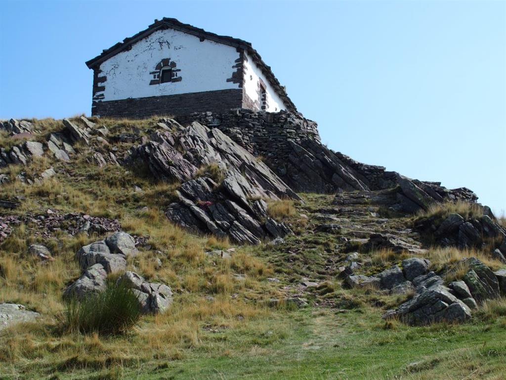 Cima del monte Mendaur donde la Ermita se cimenta sobre las areniscas rojizas del Triásico Inferior con buzamiento moderado hacia el sur.