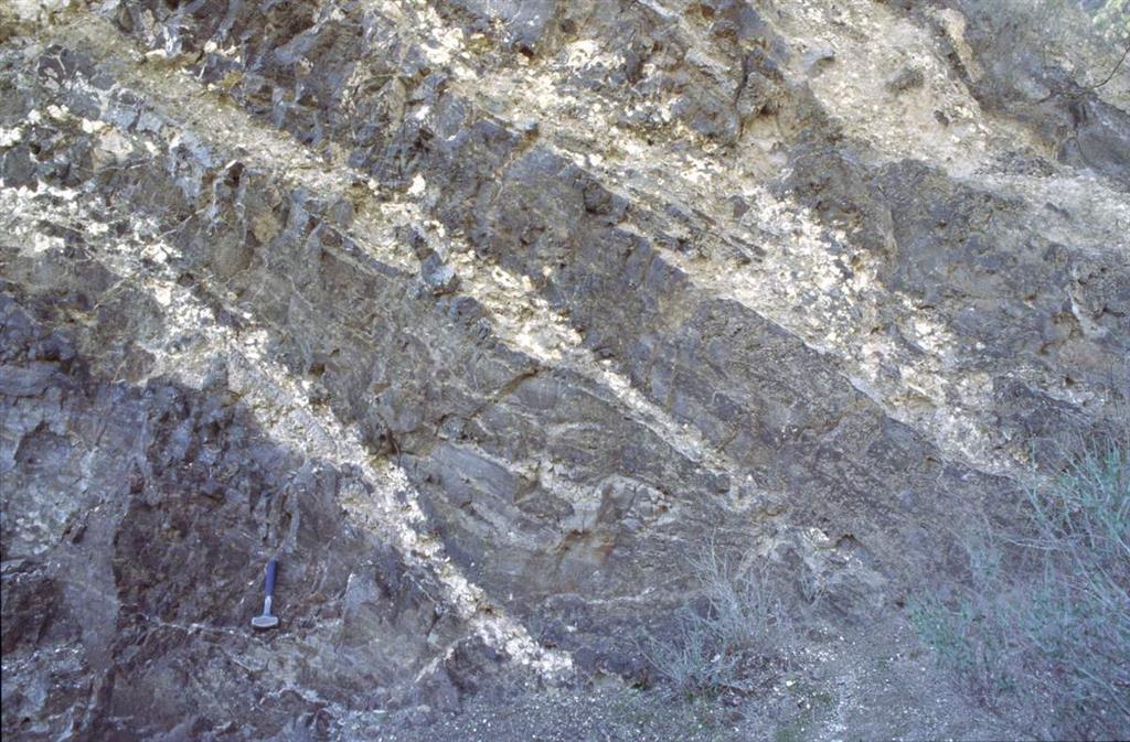Alternancia de coladas oscuras y brechas volcanosedimentarias e freatomagmáticas de colores más claros, en las canteras situadas bajo el domo-colada de la Sierra de las Cabras (Foto J.L. Brandle)