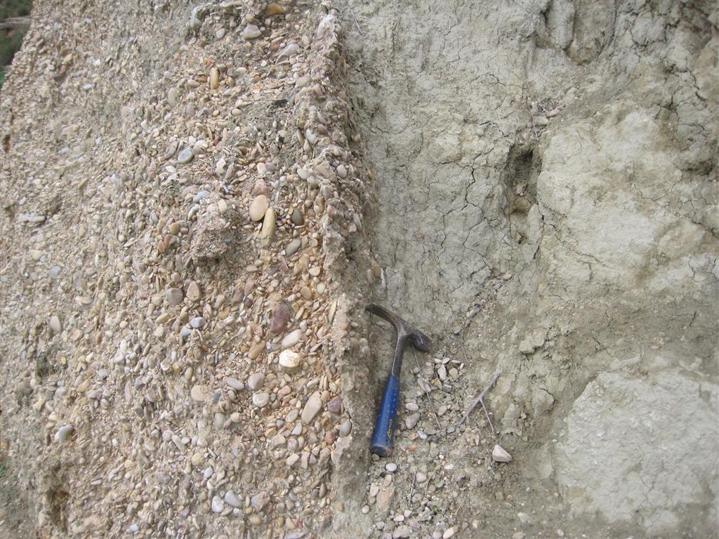 Contacto por falla inversa entre las arcillas gris-verdosas del Mioceno y gravas del Cuaternario