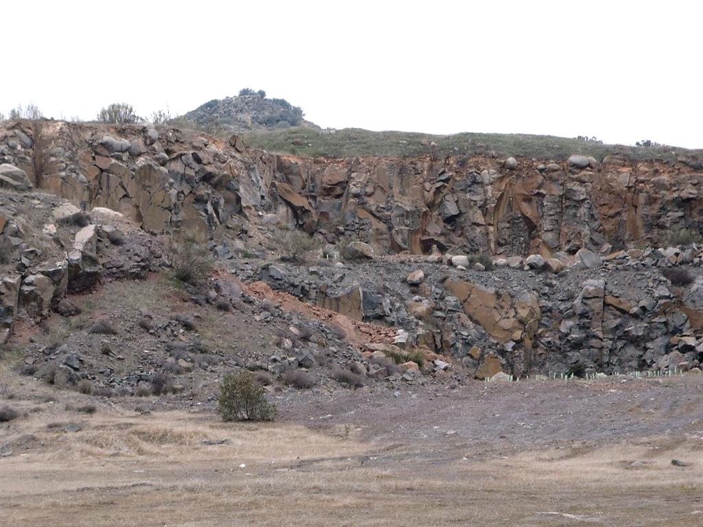 Vista parcial de la cantera excavada en la colada volcánica. Detrás se aprecia el pitón volcánico.